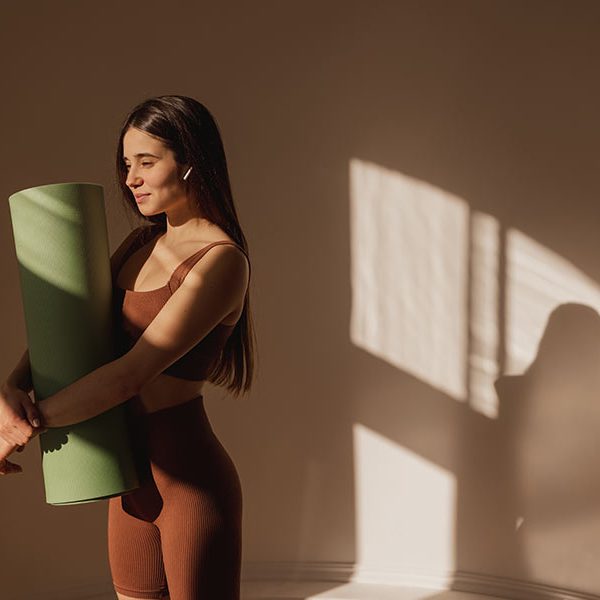Person practicing simple yoga poses for daily calm in a peaceful indoor setting.
