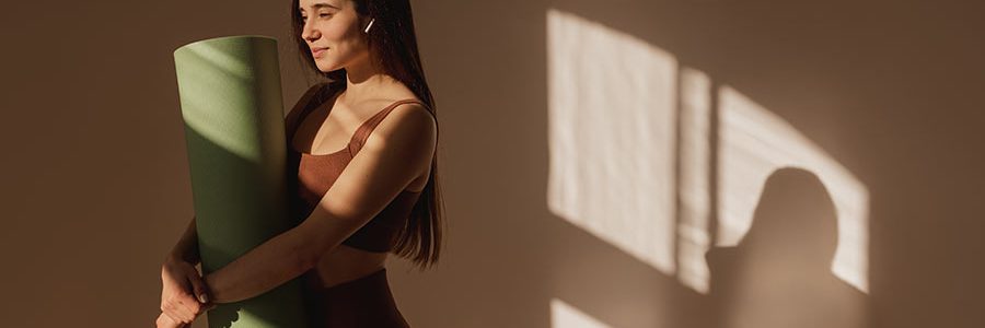 Person practicing simple yoga poses for daily calm in a peaceful indoor setting.
